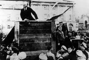 Russian revolutionary leader Vladimir Lenin (1870 - 1924) speaks to a crowd; fellow revolutionary Leon Trotsky (1879 - 1940) can be seen standing beside the platform on the right looking out over the crowd, Sverdlov Square, Moscow, May 5, 1920.  (Photo by Time Life Pictures/Mansell/Time Life Pictures/Getty Images) VLADIMIR LENIN (1870-1924). Vladimir Ilich Ulyanov Lenin. Russian Communist leader. Lenin addressing Russian soldiers about to fight the Polish Army, Petrograd, Russia, 1920. Leon Trotsky and Lev Borisovich Kamenev stand at right.